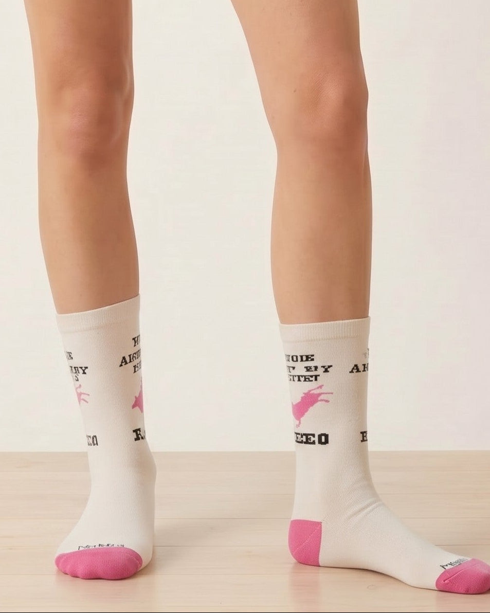 Bridle Up Hope Shop Ain't My First Rodeo crew socks in marshmallow bamboo blend with pink accents on a model