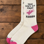 Bridle Up Hope Shop marshmallow crew socks with pink rodeo graphic and text on a rustic wooden background