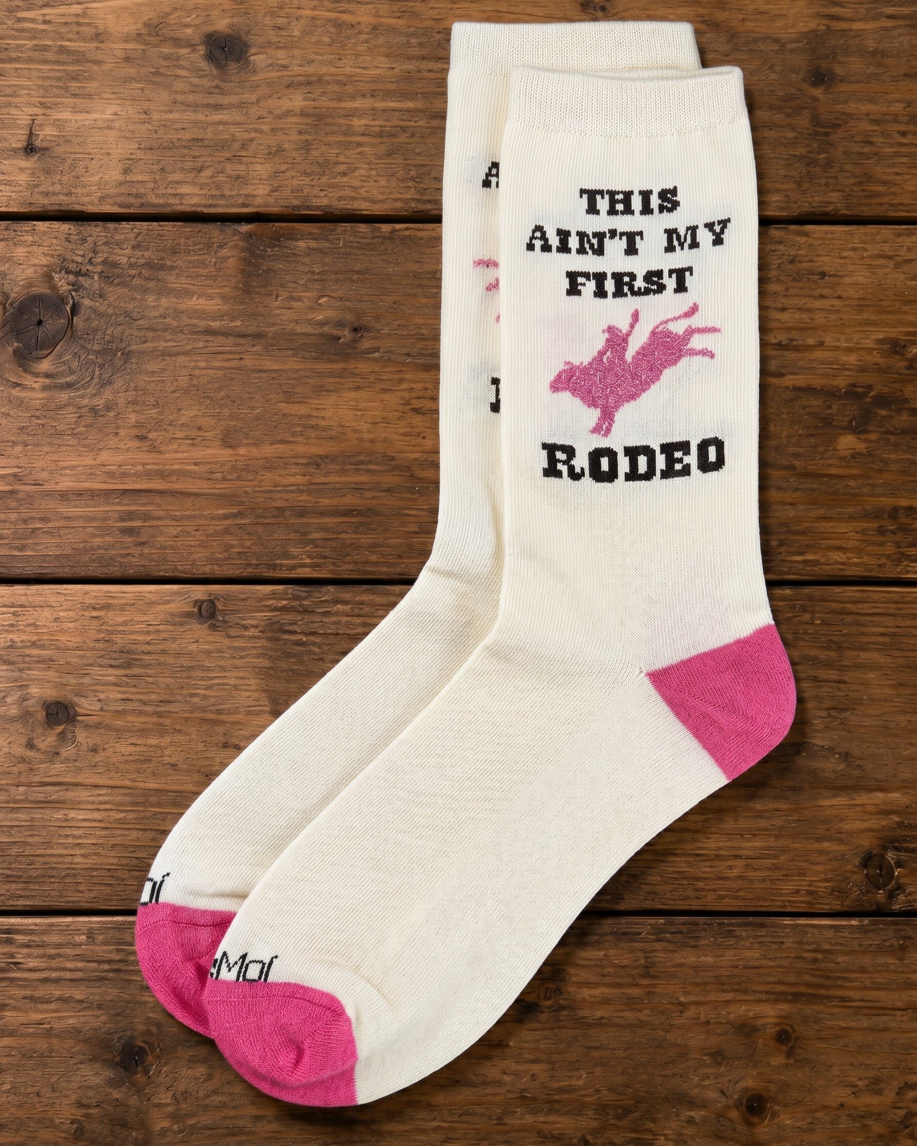 Bridle Up Hope Shop marshmallow crew socks with pink rodeo graphic and text on a rustic wooden background